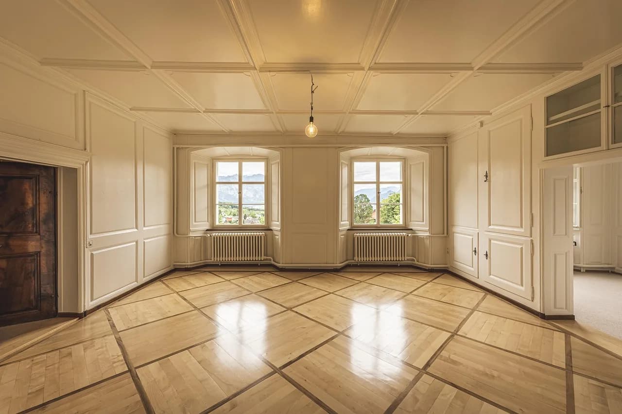 An empty room with parquet floors, before a stage