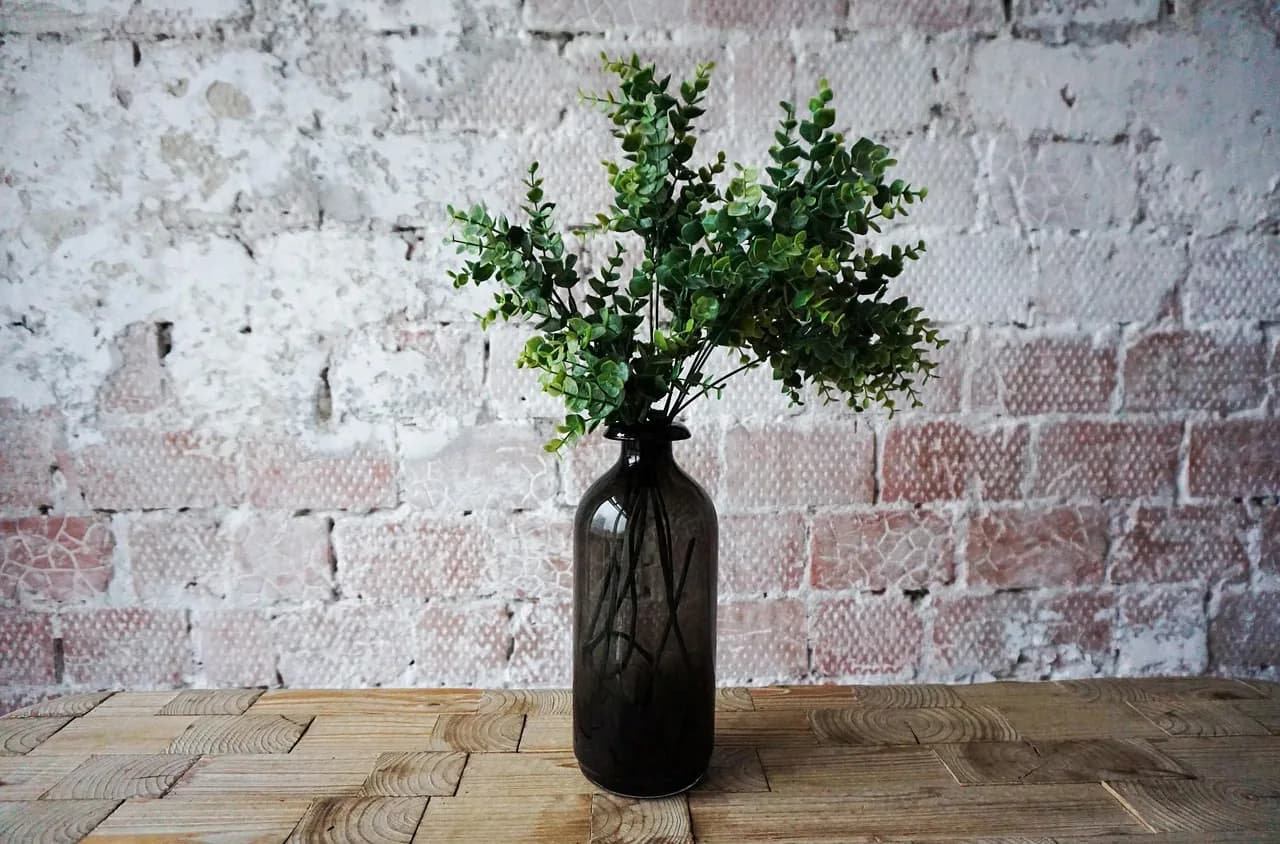 A vase against a whitewashed brick wall